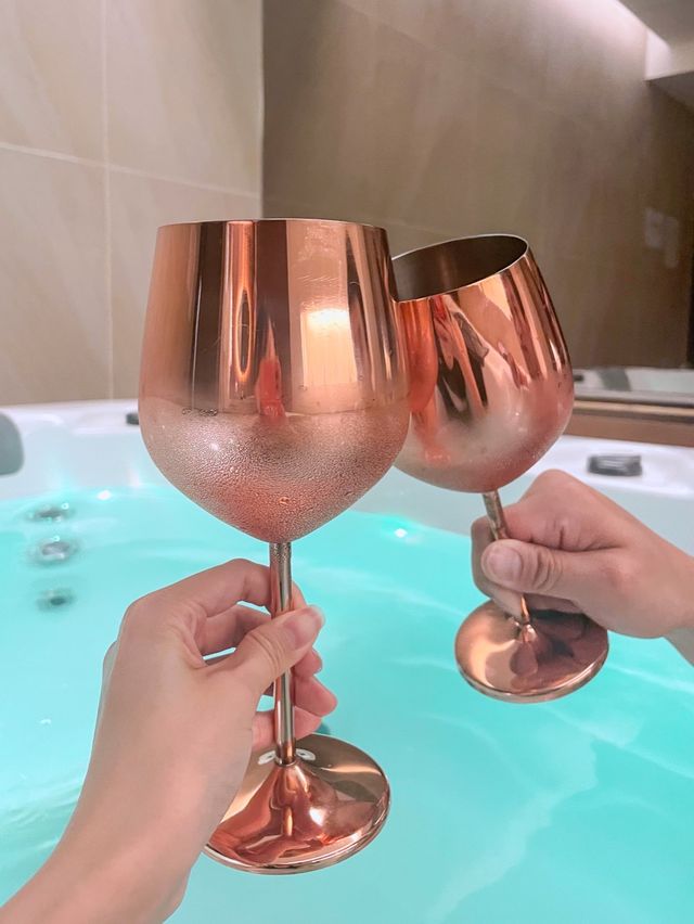 고급 스파 욕조에서 와인을 마시며 휴식하는 여행객