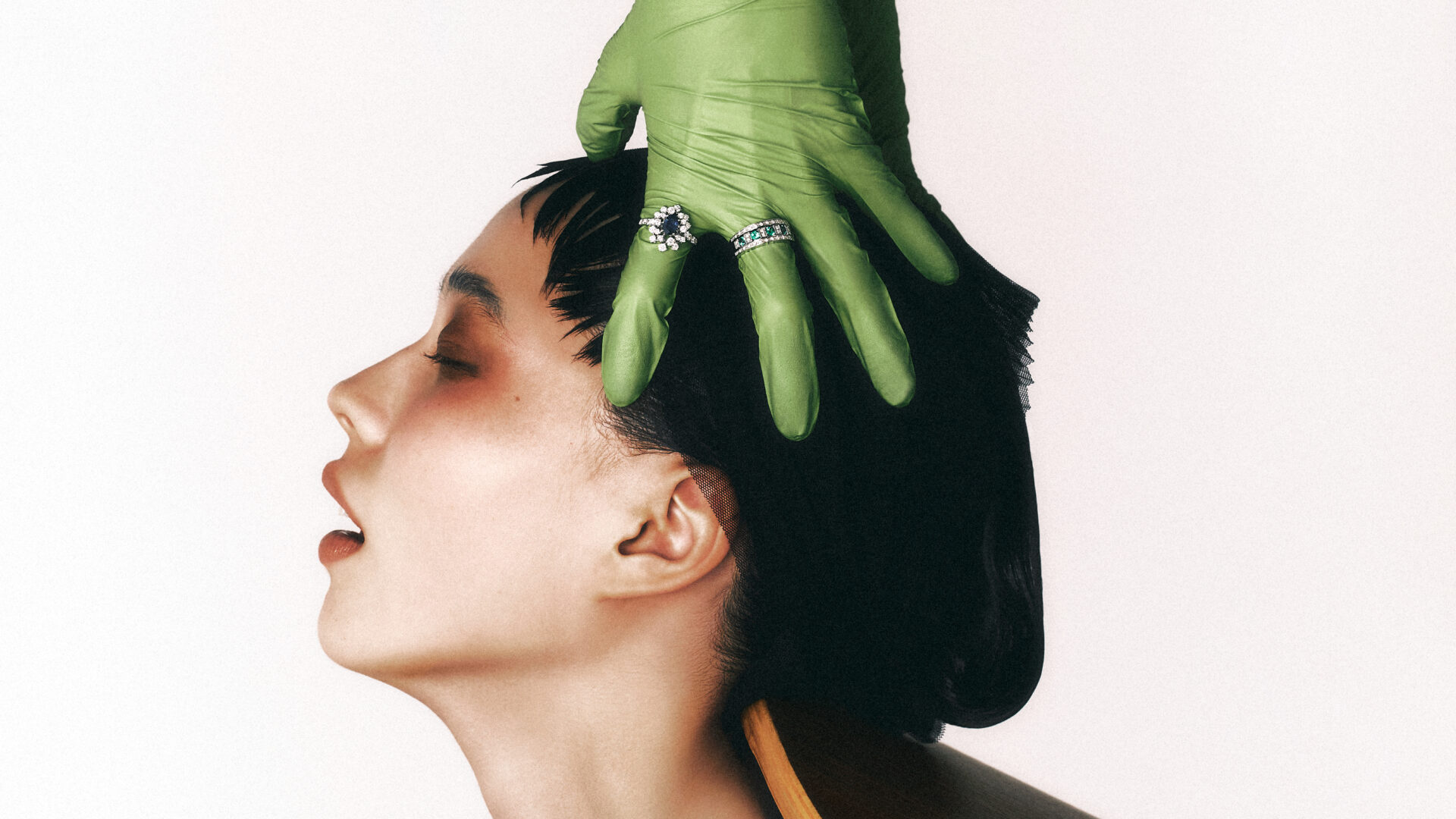 Hands of a professional massaging an essence into the scalp while undergoing a head spa treatment