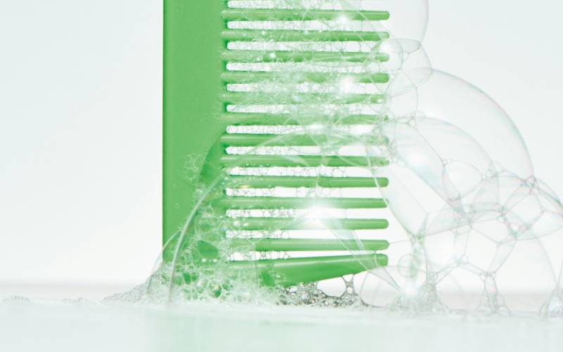 A cleansing scene created by a green scalp care comb and foam