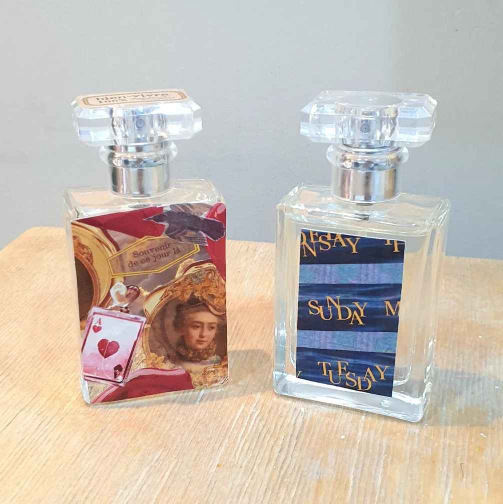 Two handmade perfume bottles placed on a wooden table