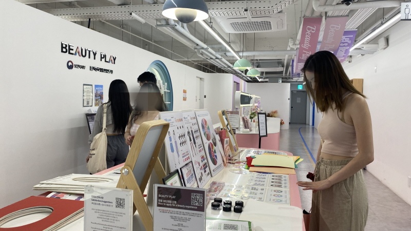 At Myeongdong Beauty Play Experience Space, foreign tourists are looking at cosmetics