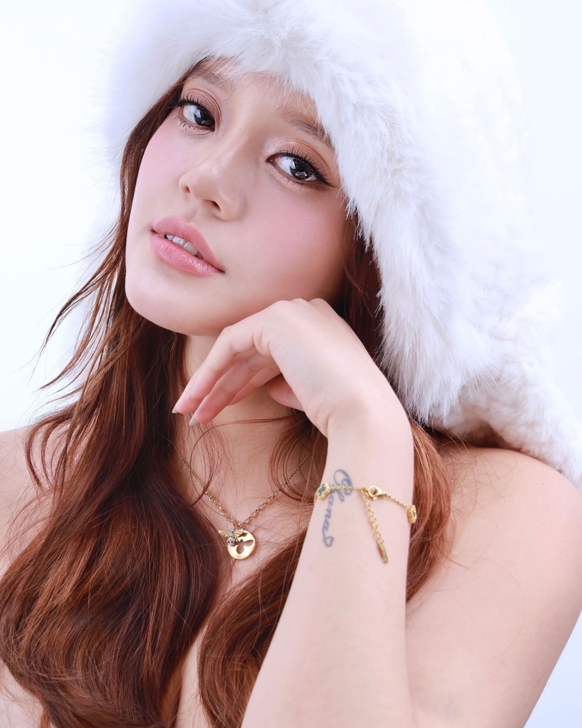 Profile photo of a woman styled in K-beauty wearing a white hat and taking a shot, with makeup and hair finished