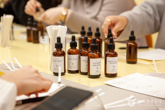 A scene of several class participants experiencing fragrance blending in the perfume class, with fragrance ingredients placed in front of them in brown-colored bottles
