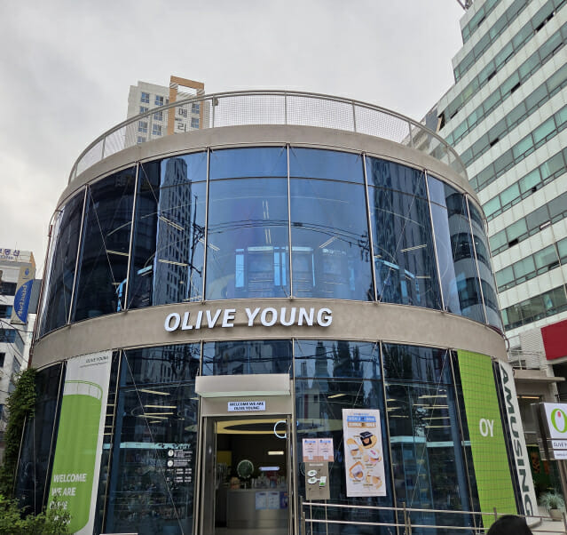 부산 해운대의 올리브영 매장 외관, 초록색과 흰색으로 디자인된 현대적인 건물 외벽