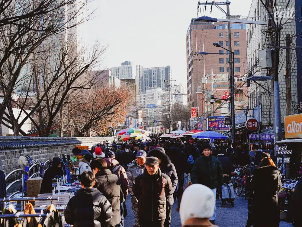 A view of street stalls and vintage shops lined up along the wall of Dongmyo Market