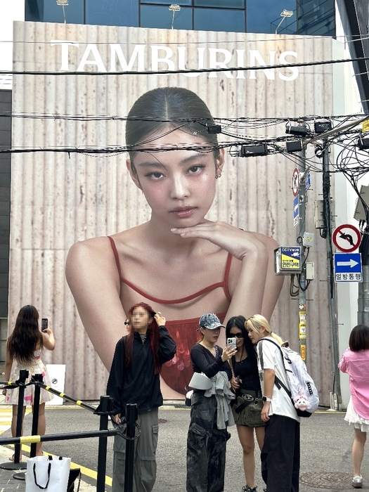 Tourists taking commemorative photos in front of the Tamburins Sinsa flagship store on Garosu-gil