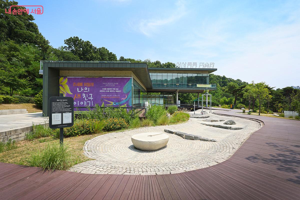 A water play area is set up in front of the Sangsang Toktok Art Museum