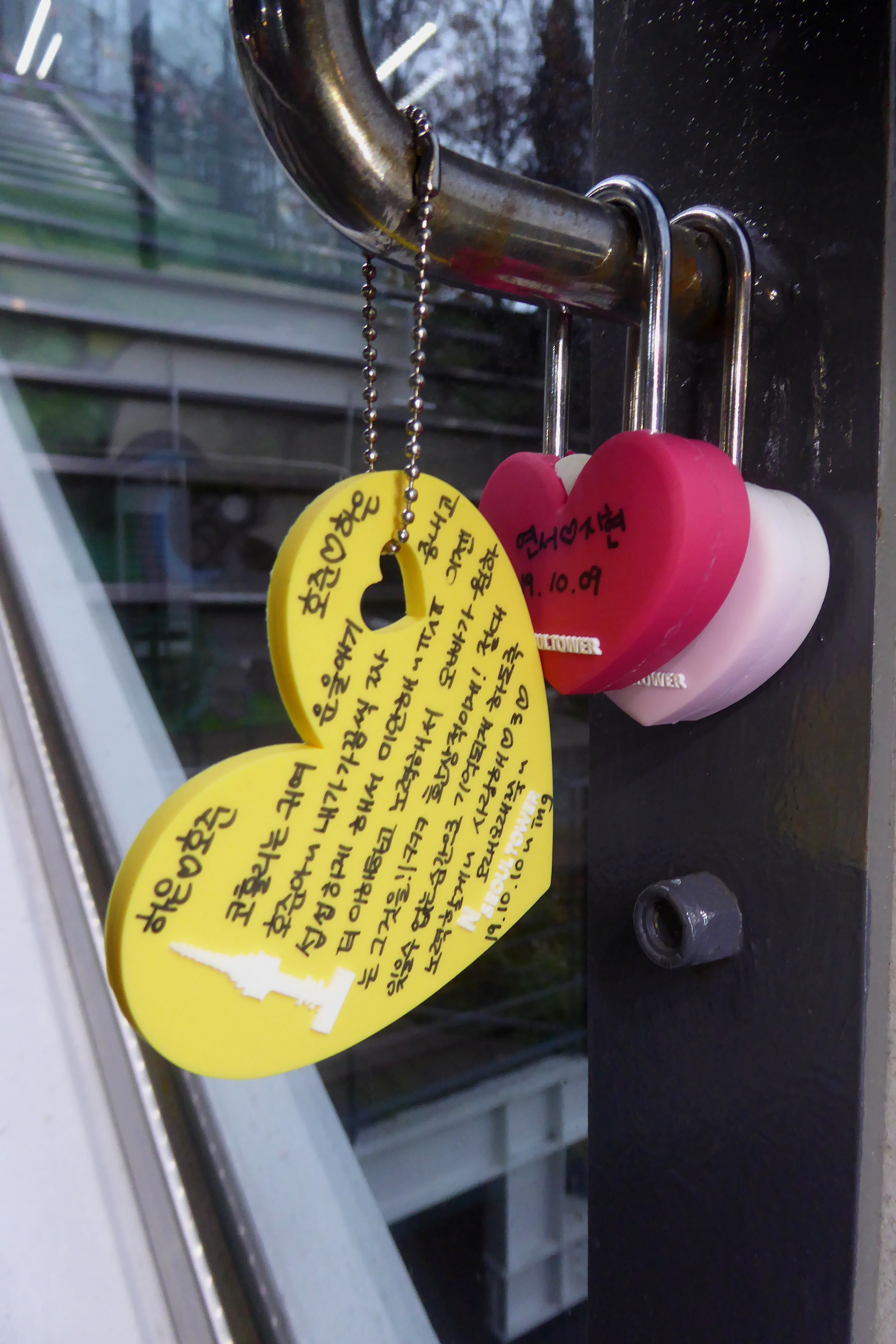 NHeart-shaped love locks hanging on the railing of Seoul Tower.