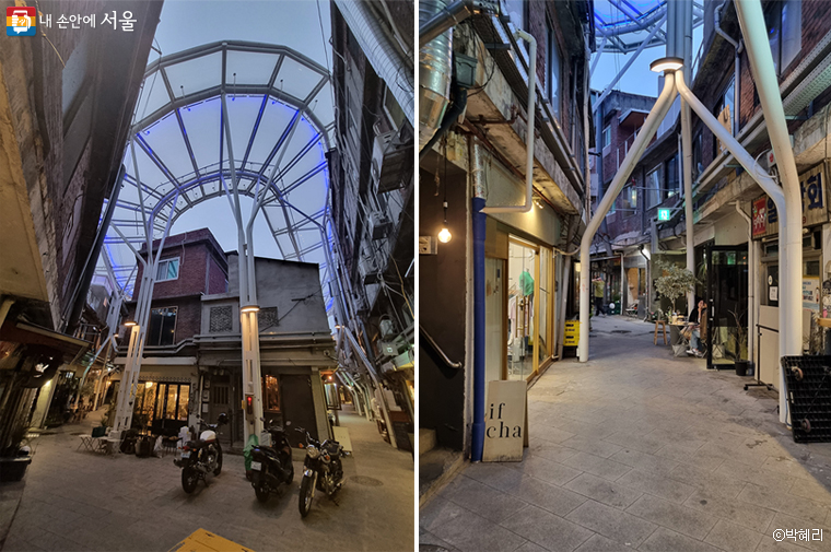 This is the passageway of Haebangchon Sinheung Market continuing beneath a transparent arcade roof..