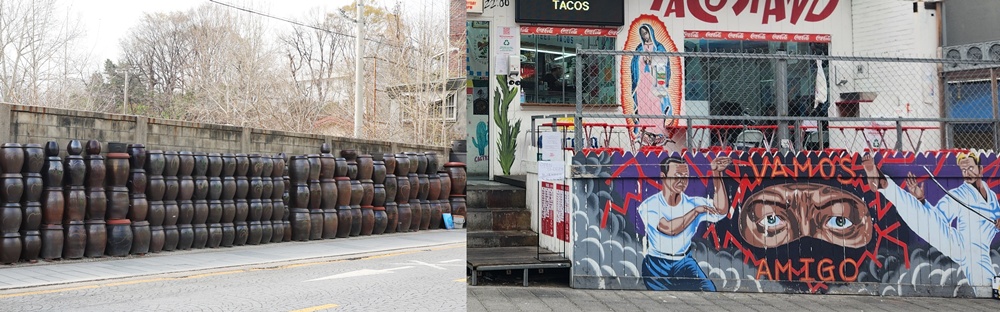 This is an alley scene at the entrance to Haebangchon with onggi jars and a mural..