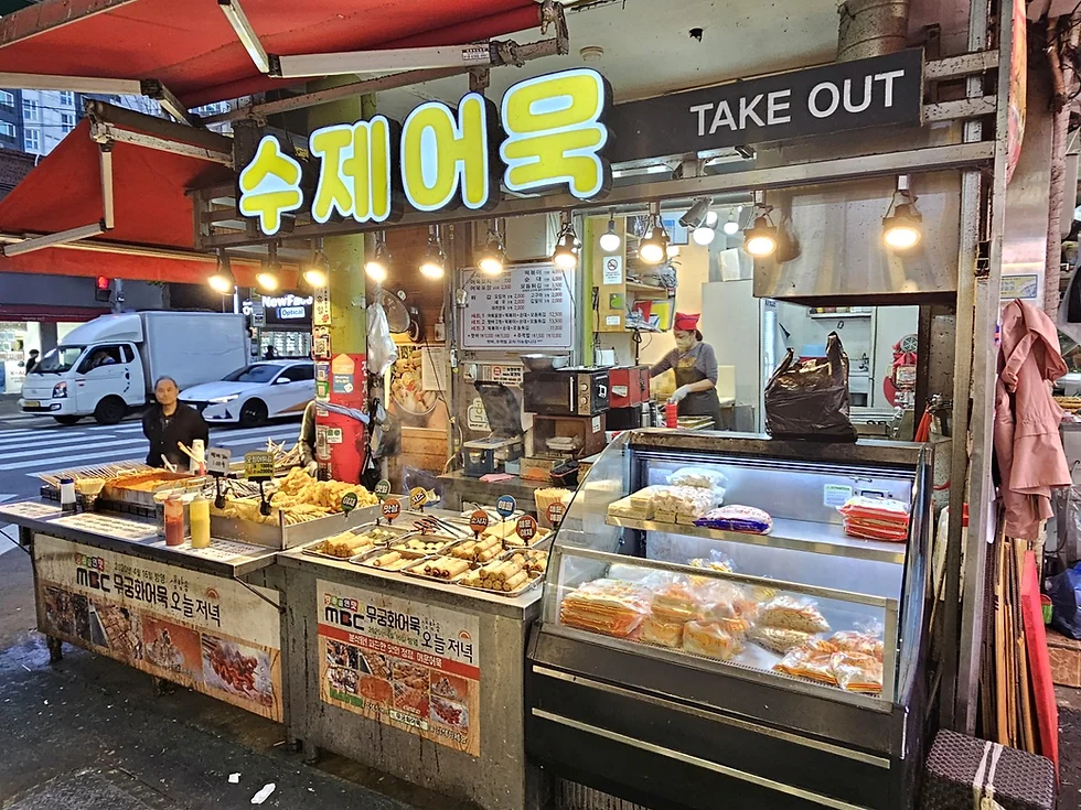 This is a view showing the handmade fish cake takeout counter and price signs at the edge of Mangwon Market..