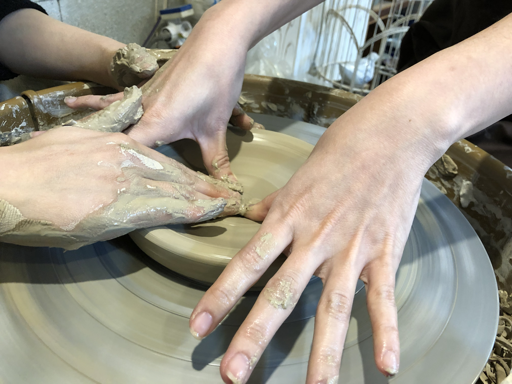 This is a hands-on workshop scene of making ceramics on a potter's wheel..