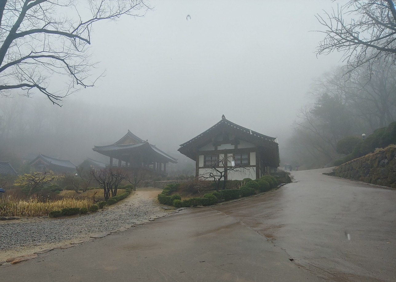 비 오는 날 안개에 잠긴 부석사 전각과 젖은 산사 길 풍경입니다.
