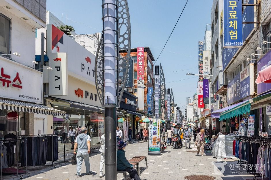 전통시장 진열대와 판매 상품을 볼 수 있는 장면입니다.