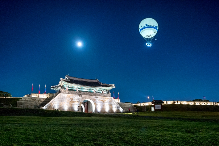 밤의 수원화성과 플라잉수원이 함께 보이는 장면입니다.