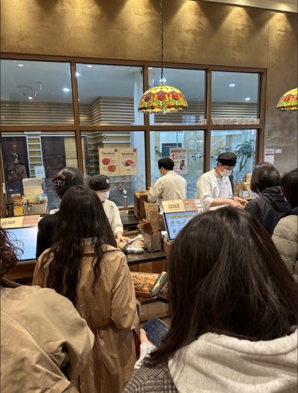 성심당 DCC점 내부 계산대 앞에 결제를 기다리는 손님들이 보입니다.