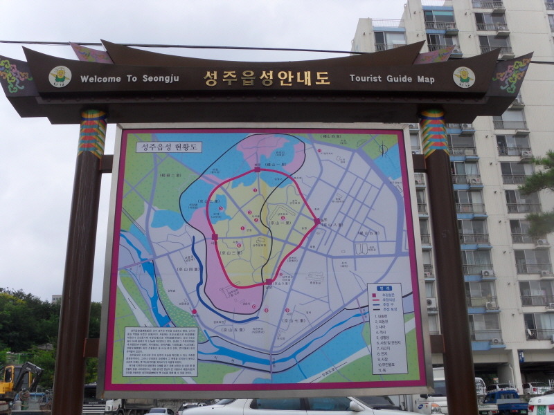 성밖숲 안쪽에서 굵은 왕버들 줄기와 둥근 벤치를 바라본 모습입니다.