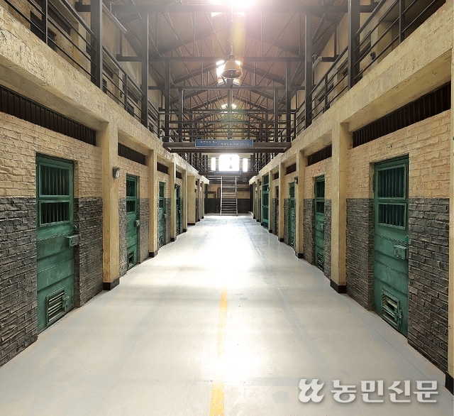 굳게 닫힌 철문과 쇠창살이 교도소 내부 촬영 세트의 분위기를 보여줍니다.
