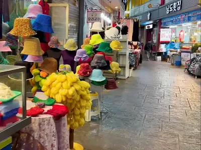 교동시장 골목에 형형색색 코바늘 모자와 가방이 진열되어 있습니다.