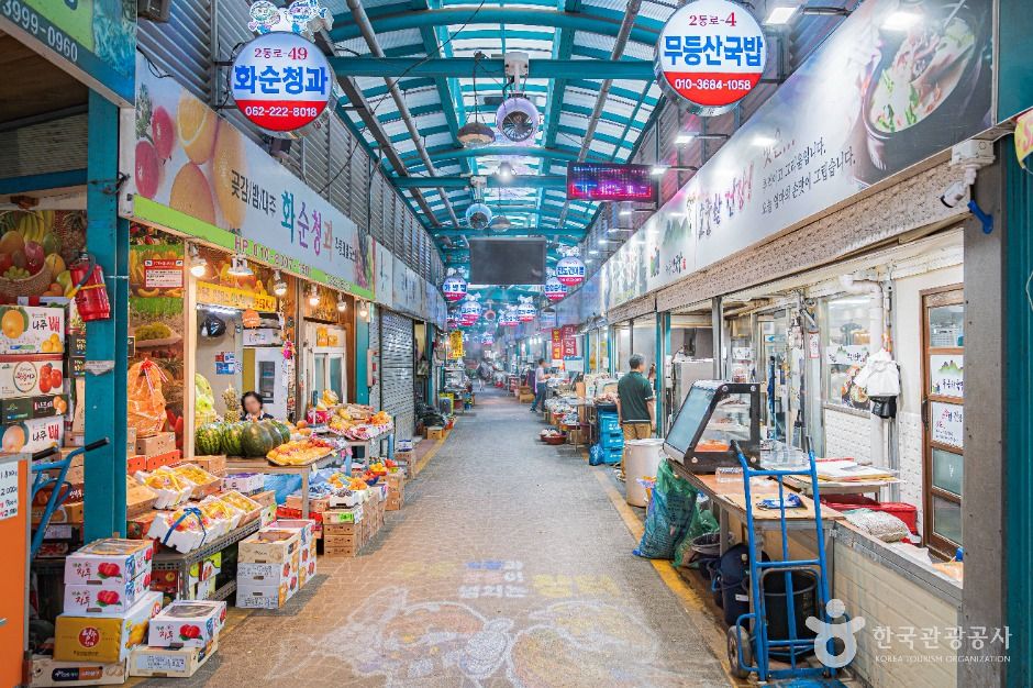 남광주시장의 낮 시간대 상점가를 보여 주는 장면입니다.