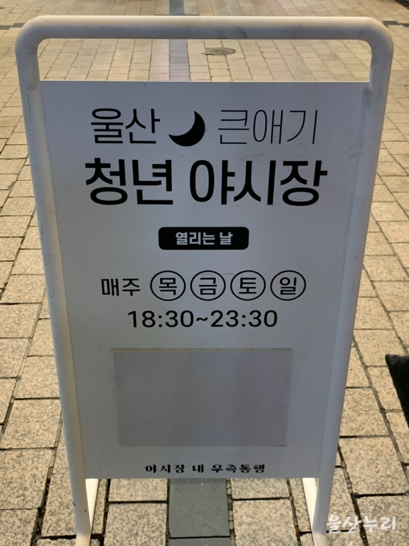 야시장 먹거리 판매대에서 음식을 고르는 장면입니다.