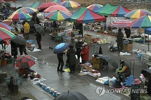 천막 아래 상인과 손님이 오가는 전주 도깨비시장의 새벽 풍경입니다.